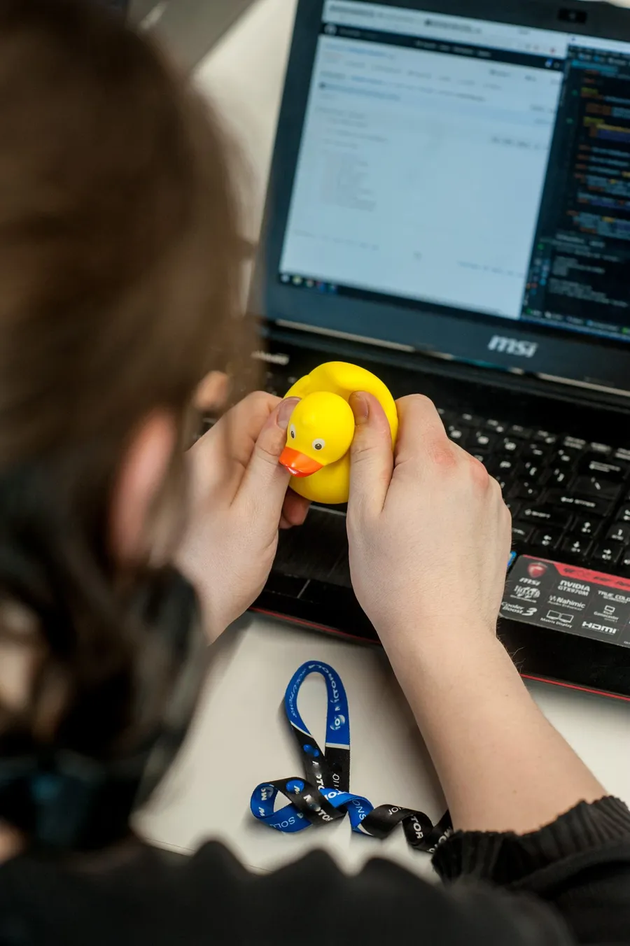 Student szukający błędu w kodzie z żółtą kaczką